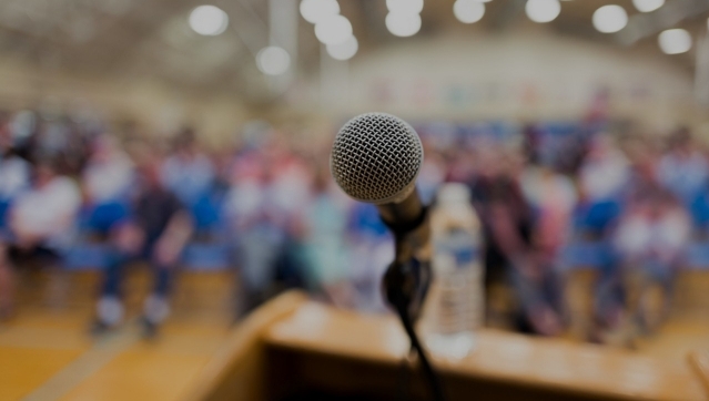 Microphone on podium with crown in the background 